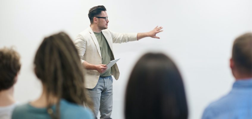 A lecturer standing in front of a class.