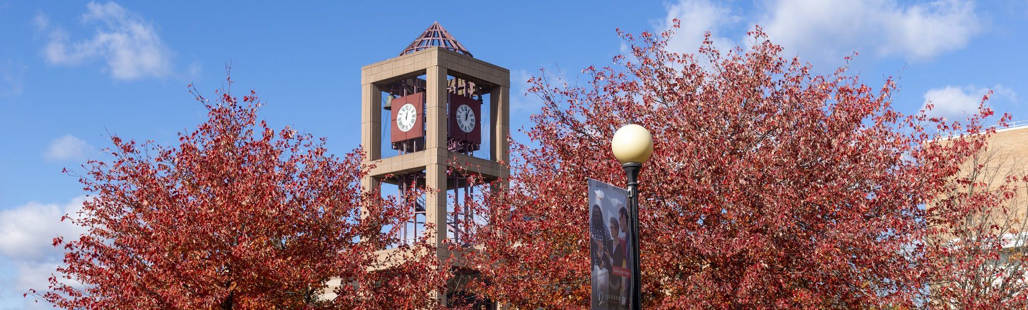 Photo of QC Clock Tower and surrounding trees in spring.