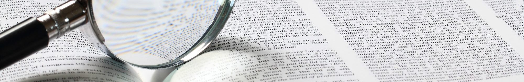 An image of a magnifying glass atop a book